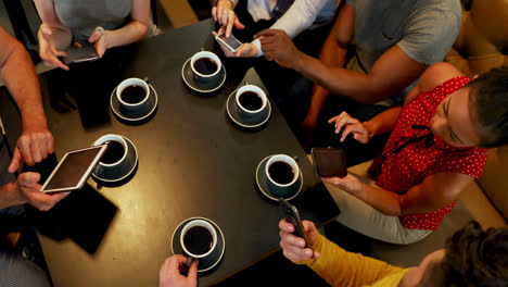 group of friends using mobile while having coffee 4k 4k