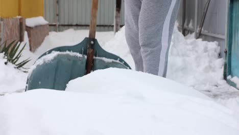 Nahaufnahme-Einer-Person,-Die-Nach-Einem-Schneesturm-Den-Hof-Schaufelt