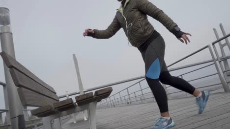 mujer bruneta hindú sonriente entrenando en un muelle de madera