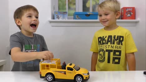 two boys excitedly playing with toy truck in playroom
