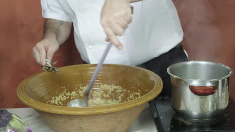 italian chef cooks cous cous boils soup in homey european kitchen hands closeup