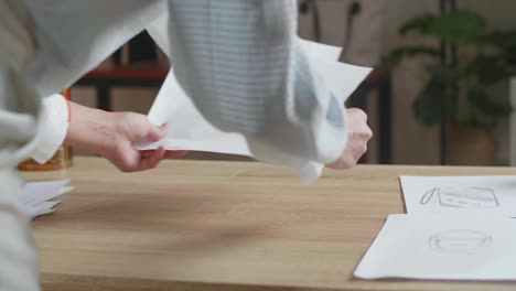 un primer plano de una mujer asiática diseñadora está arreglando el diseño de la fianza en la mesa de la oficina