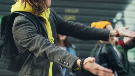 close-up view of stylish young hipster man dancing and having fun with his friends in the street