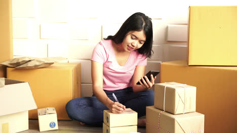 asian women business owner working at home with packing box on workplace