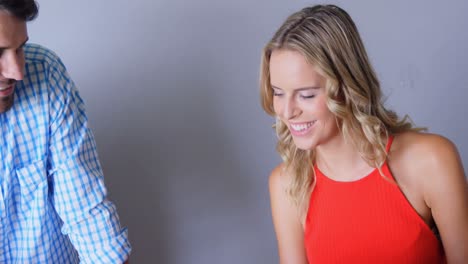 una pareja linda sonriente usando el teléfono en el frente
