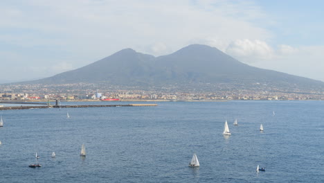 sailboats in the gulf of naples with mount vesuvius volcano background