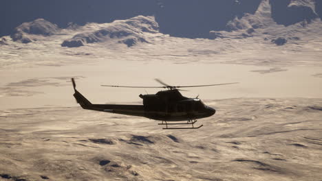 military helicopter flying over a desert landscape