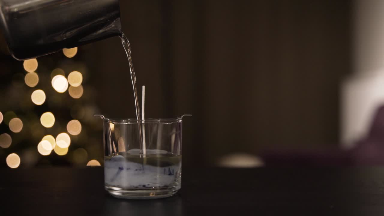 vertiendo parafina para la vela en una casa acogedora, vista de cerca