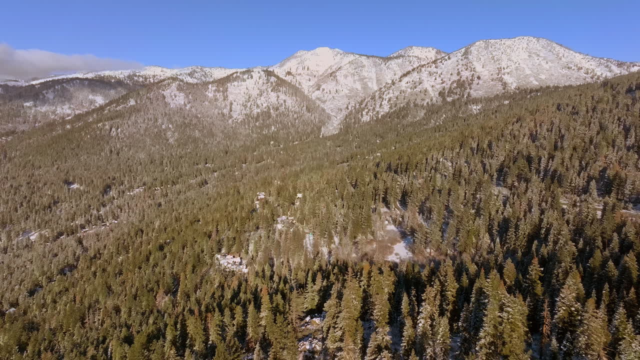 distancia aérea de las montañas y sobre los abetos de douglas y un pequeño trozo de carretera en el lago tahoe, nevada en un hermoso cielo azul día de invierno