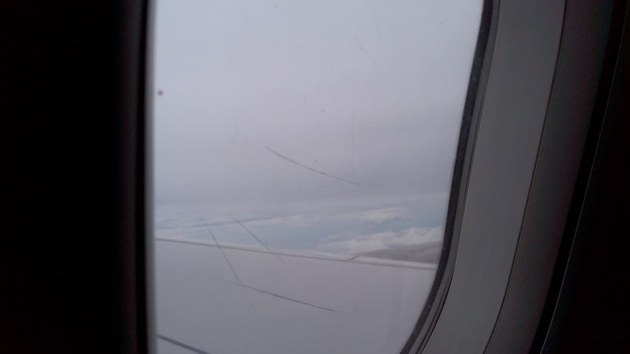 вид на поверхность окна с царапинами на поверхности во время полета по небу в дневное время