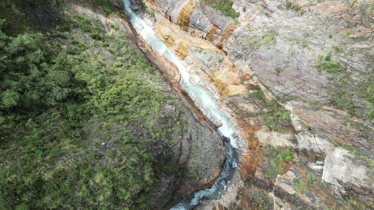 Ripresa aerea di un drone sul canyon della foresta pluviale, pareti rocciose arancioni a contrasto con le rapide del fiume blu brillante sottostante