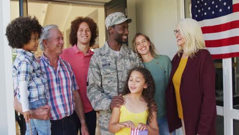 Video-Einer-Glücklichen,-Vielfältigen-Familie-Mit-US-Flaggen,-Die-Vor-Dem-Haus-Steht