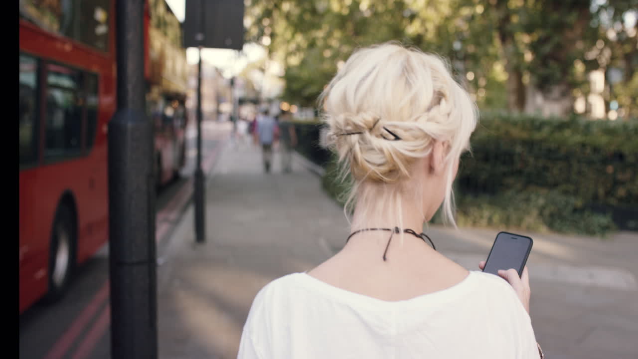 도시에서 스마트 폰을 사용하는 아름다운 금발