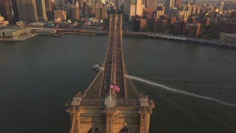 AERIAL:-Flight-over-Brooklyn-Bridge-with-view-over-Manhattan-New-York-City-Skyline-at-Sunset-in-beautiful