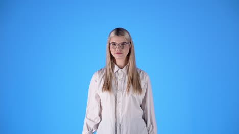 mujer con camisa blanca muestra pulgares hacia arriba, concepto de aprobación, toma de estudio