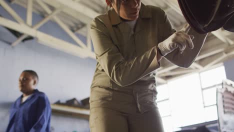 video of biracial female car mechanic repairing car