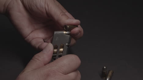 hand loads bullets into gun cartridge, slow motion