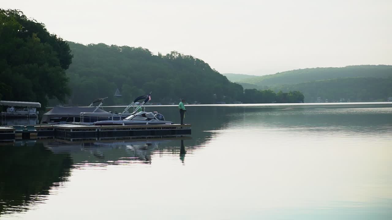 Early morning fishing by the lake with mountains and clouds