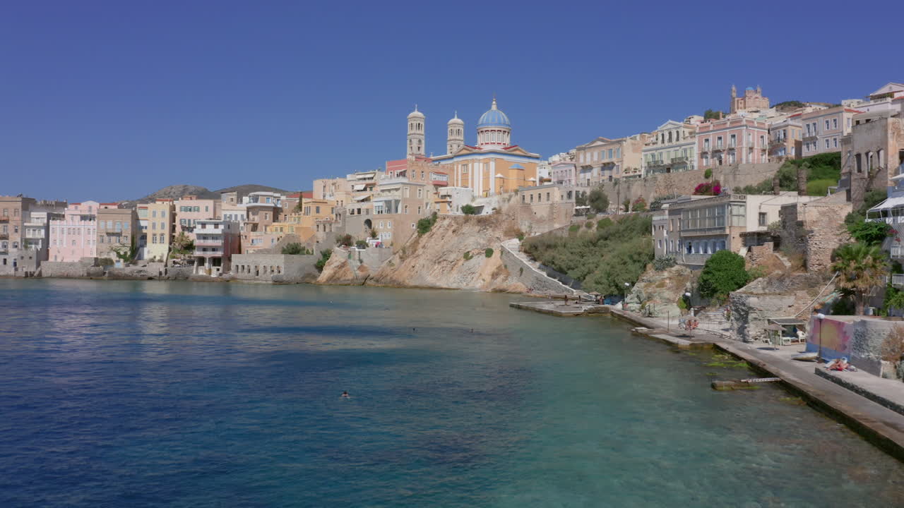 항공: 그리스 의 시로스 섬 에 있는 에르무폴리 에 있는 아스테리아 해변 의 느린 파노라마 드론 사진