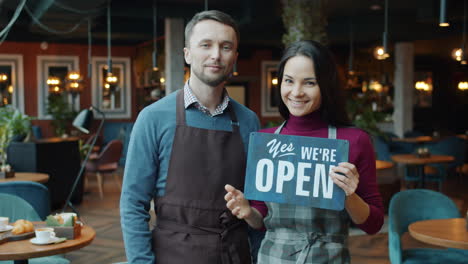 cafe staff showing open/closed signs