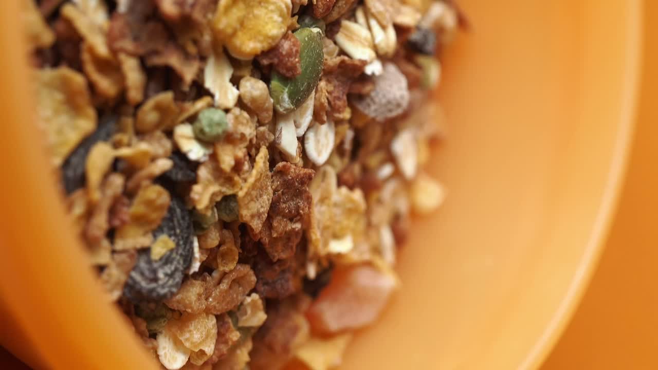 Close up of granola in an orange bowl