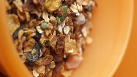 close up of granola in an orange bowl