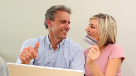 mature couple shopping online together on the couch