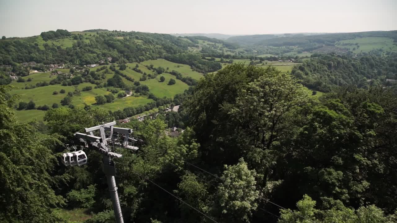 Cable cars moving down above trees at the Heights of Abraham in Derby