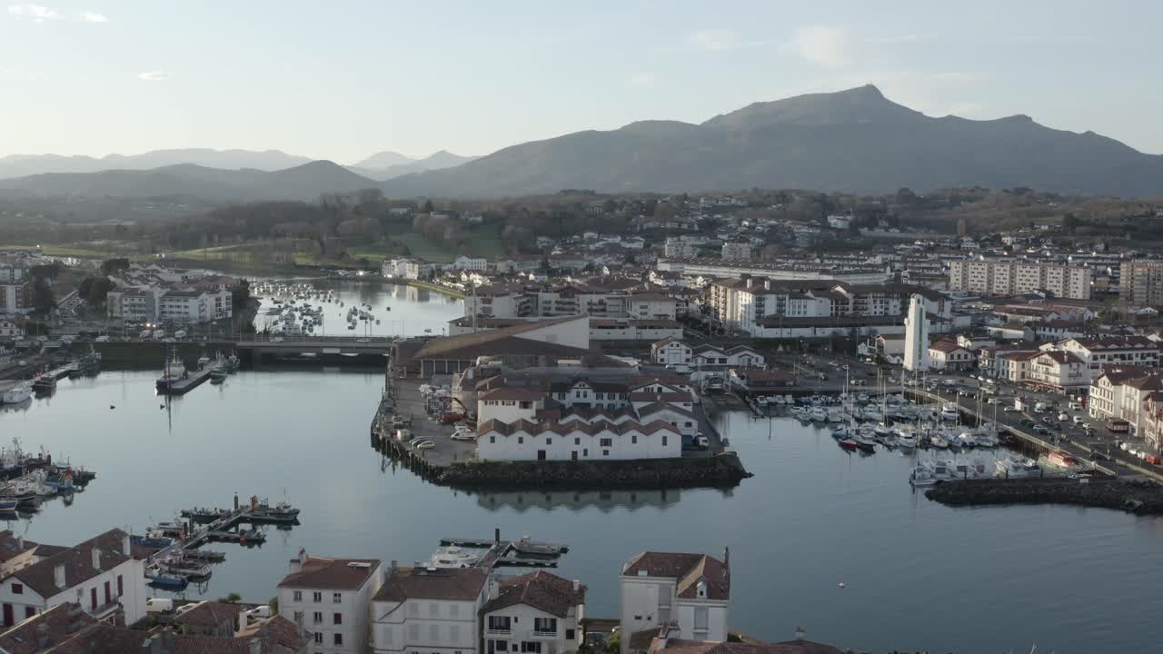 Saint-Jean-de-Luz harbor, boats, and town, with La Rhune mountain in background, Basque Country, France. Aerial drone pov