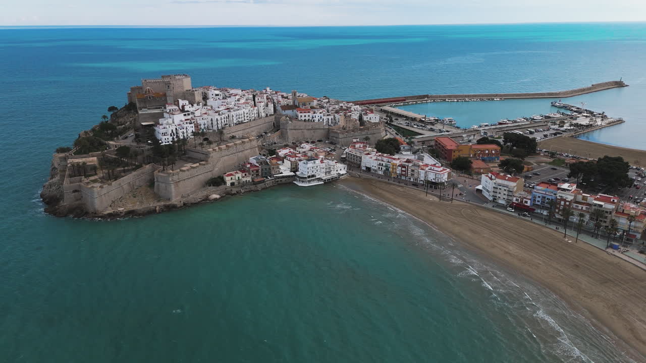 High drone angle of Peniscola coast, sandy shoreline and Castell de Peniscola visible