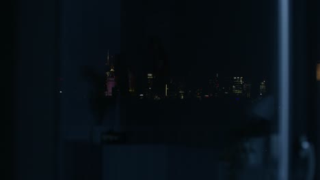 city skyline at night viewed through a window