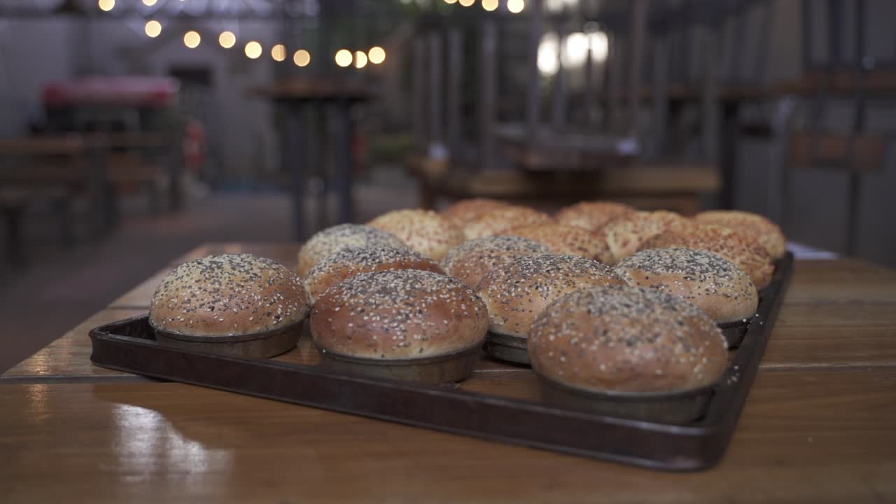 Close up orbit shot of fresh backed rolls or buns in bakery shop