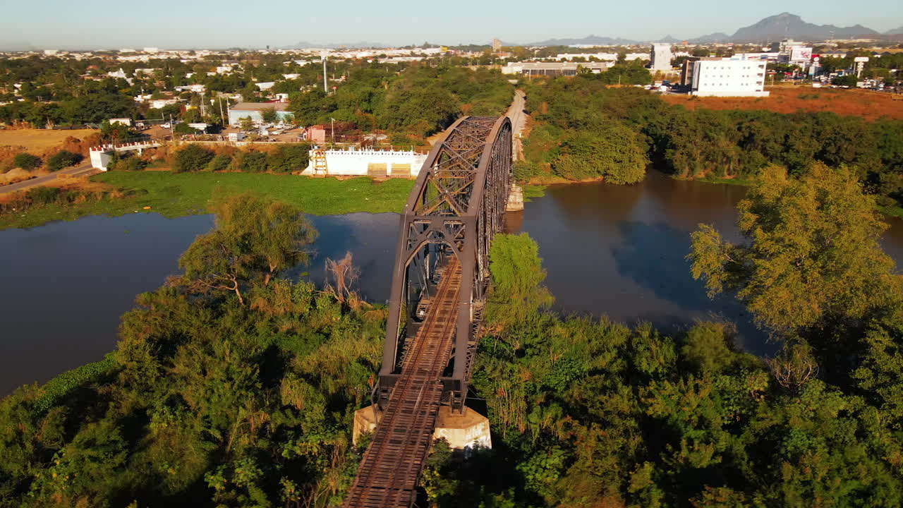 volar sobre el río, con una perspectiva única sobre un viejo puente ferroviario de hierro oxidado en la ciudad de méxico