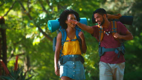 Pareja-Con-Mochilas-Chocando-Los-Cinco-En-Vacaciones-Caminando-Juntos-Por-El-Campo