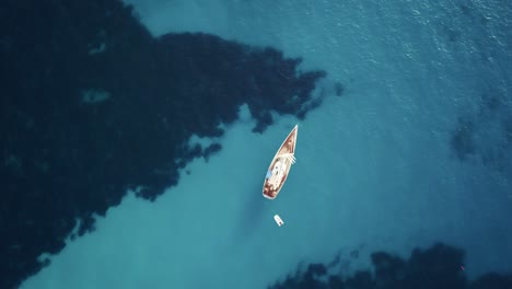 Impresionante-Vista-De-Arriba-Hacia-Abajo-En-4k-De-Un-Velero-En-Aguas-Turquesas-Cristalinas-En-El-Mar-Mediterráneo