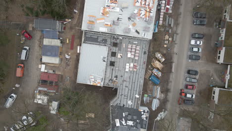 top down aerial of construction worker working under large construction site - drone setting down