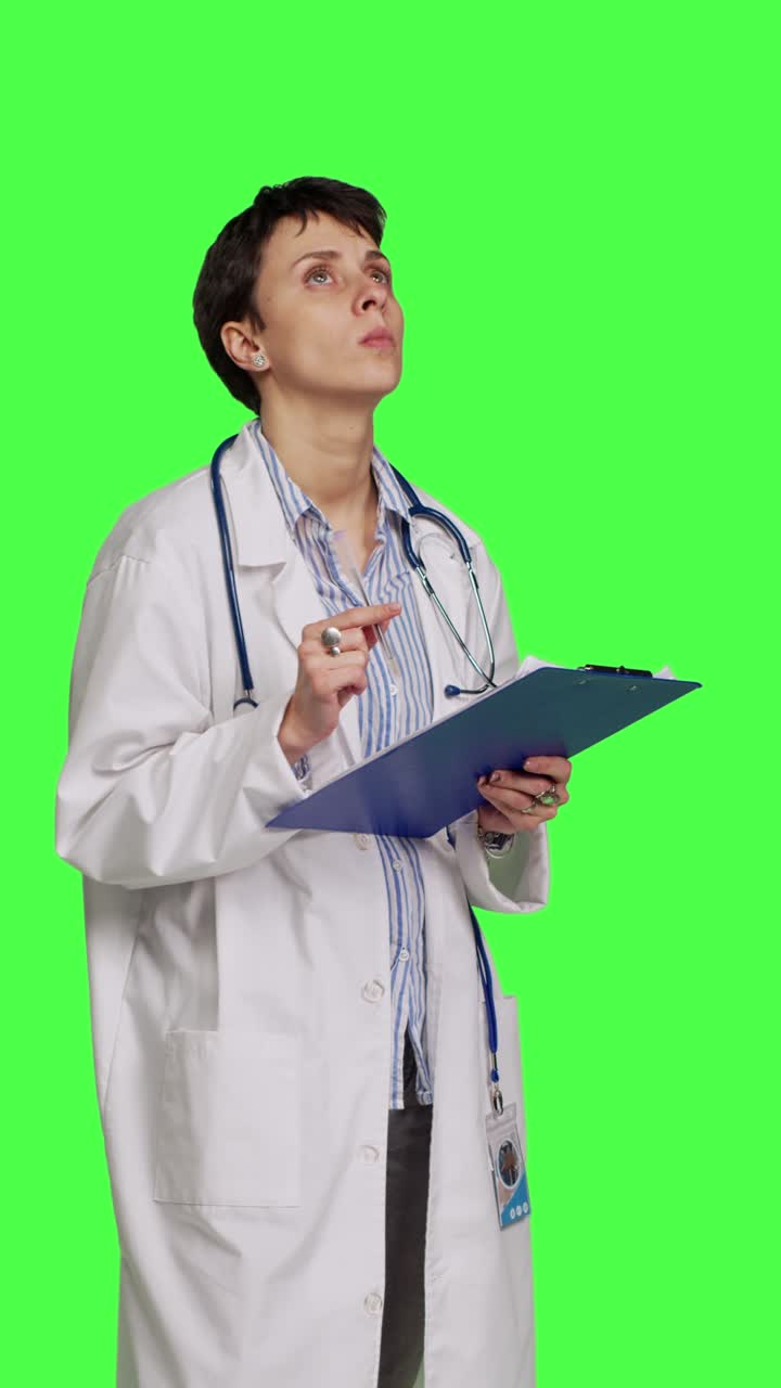 Vista laterale di un medico che prende appunti dopo aver visitato un paziente, con sfondo green screen