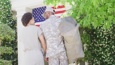 un soldado afroamericano que regresa a casa, recibido por una esposa feliz, en cámara lenta
