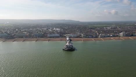 Flying-around-Eastbourne-Pier,-sea-front-and-beach