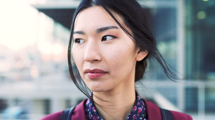 Ritratto di una giovane donna asiatica che guarda altrove all'aperto