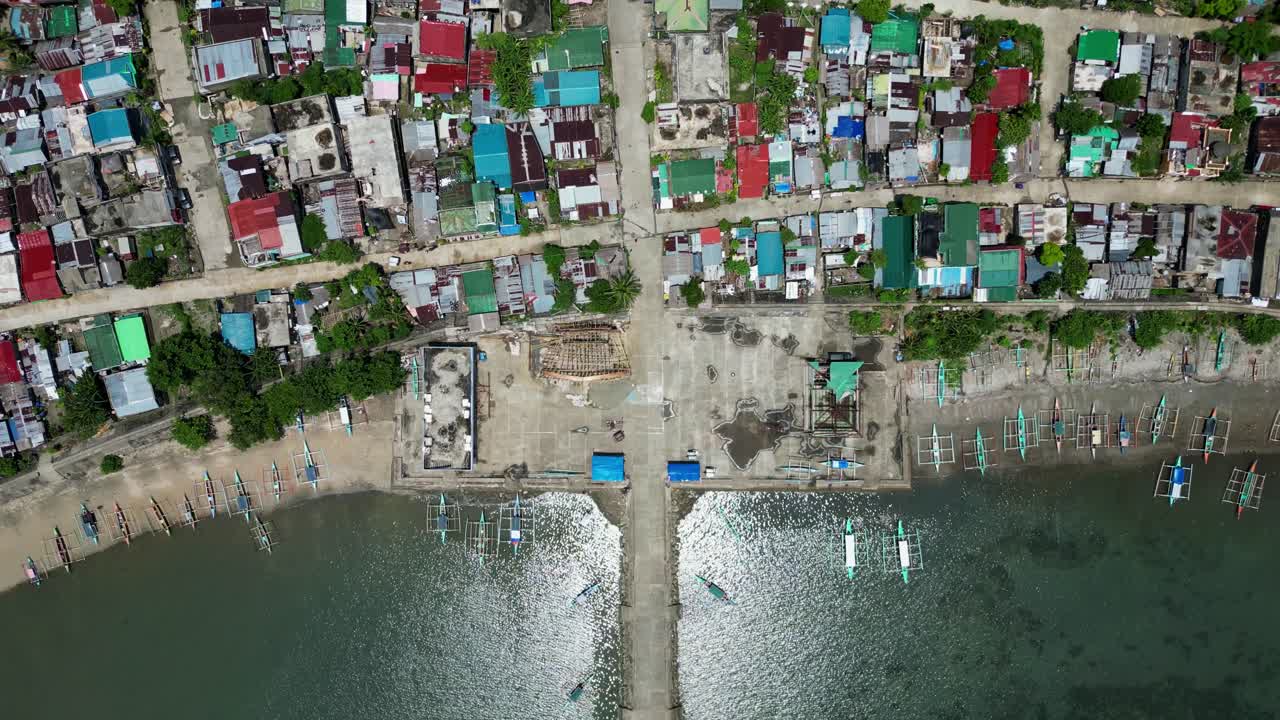 Picturesque top-down aerial view of rural barangay village along tropical island coastline at Codon Port, San Andres, Philippines