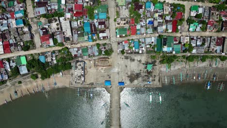 picturesque top-down aerial view of rural barangay village along tropical island coastline at codon port, san andres, philippines