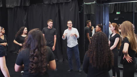 maestro con estudiantes de teatro en la escuela de artes escénicas en la clase de improvisación de estudio