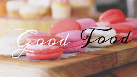 colorful macarons on wooden board with good food text animation over them