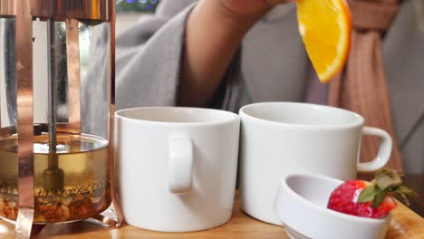 woman enjoying a cup of tea with fruit