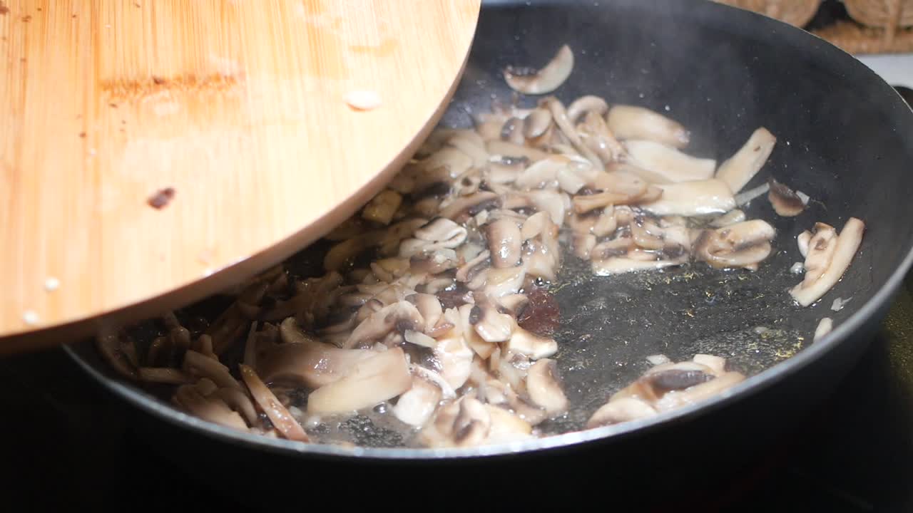 Cooking mushrooms and peppers in a pan