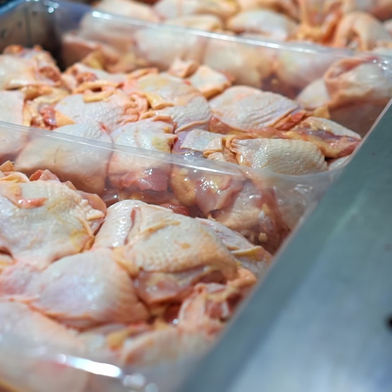Fresh chicken meat production. Raw chicken meat parts in containers in refrigerator on a poultry processing factory