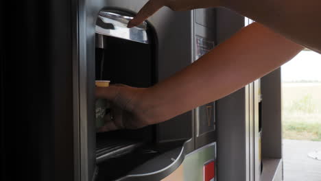 person using a hot drink vending machine outdoors