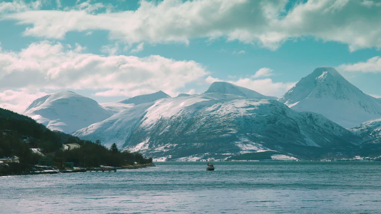 Scatto mozzafiato di una barca sul fiordo di Lyngen, con montagne sullo sfondo