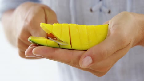 Mid-section-of-woman-chopping-mangoes